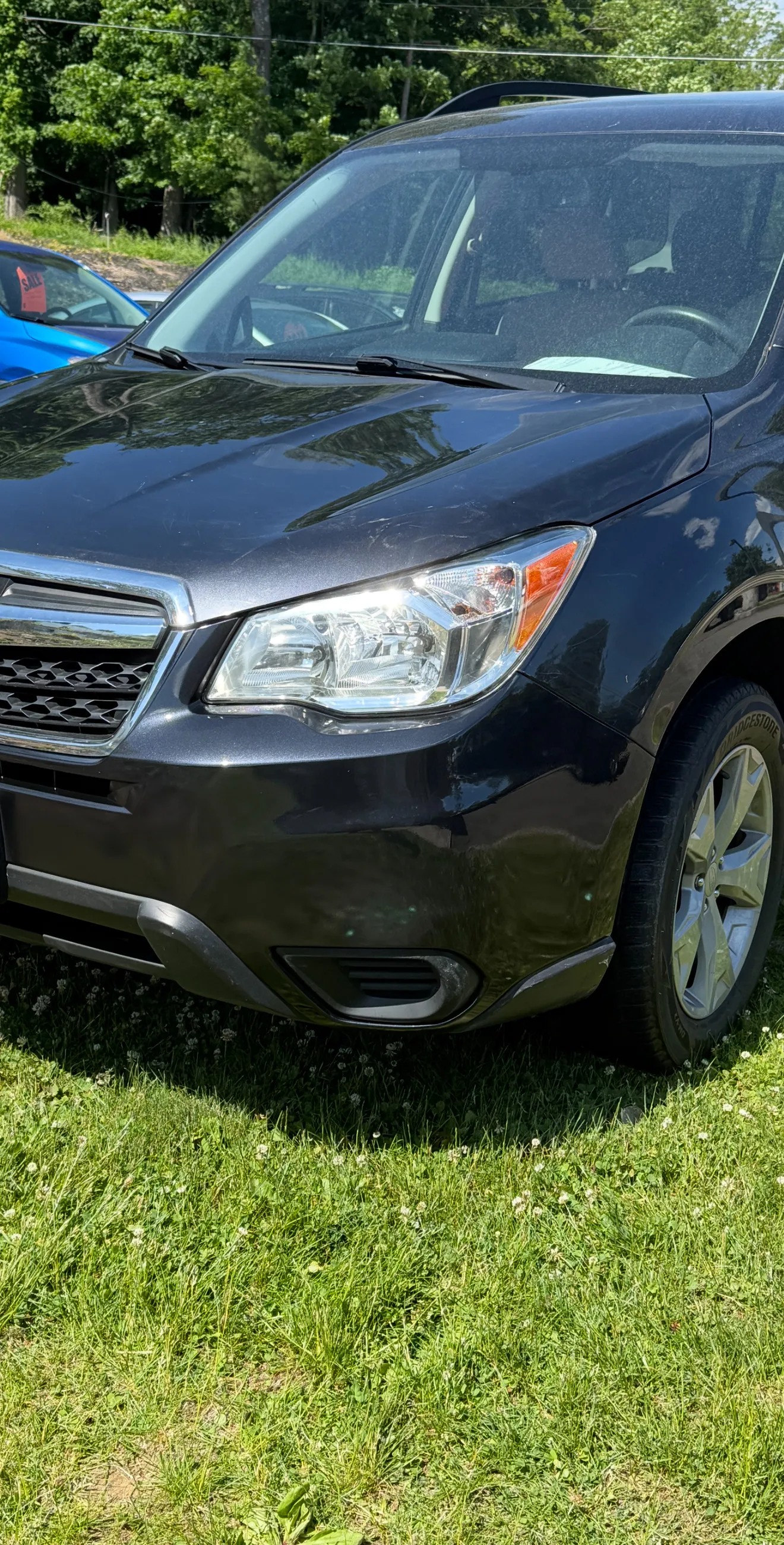 Same Subaru Forester front bumper corner after repair, smooth and color-matched.
